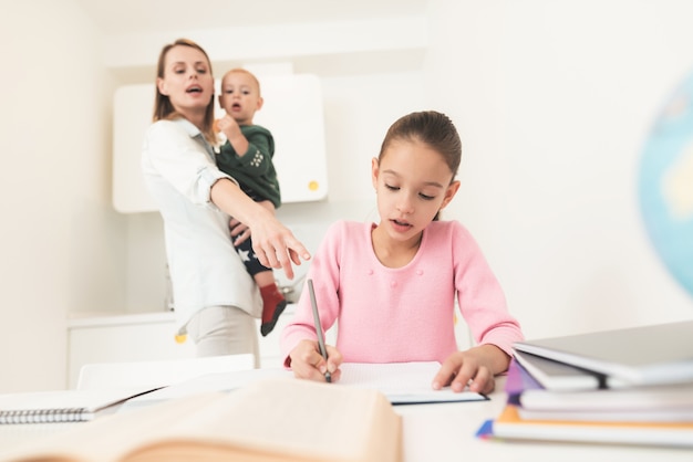 Young girl doing homework in the kitchen 