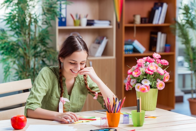 Young girl drawing pictures at home