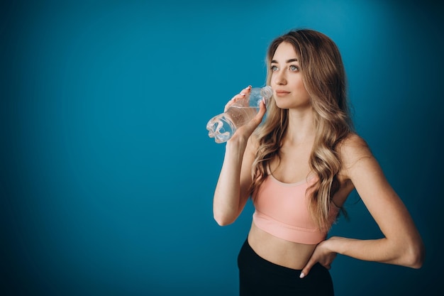 young girl drinking water after training in studio