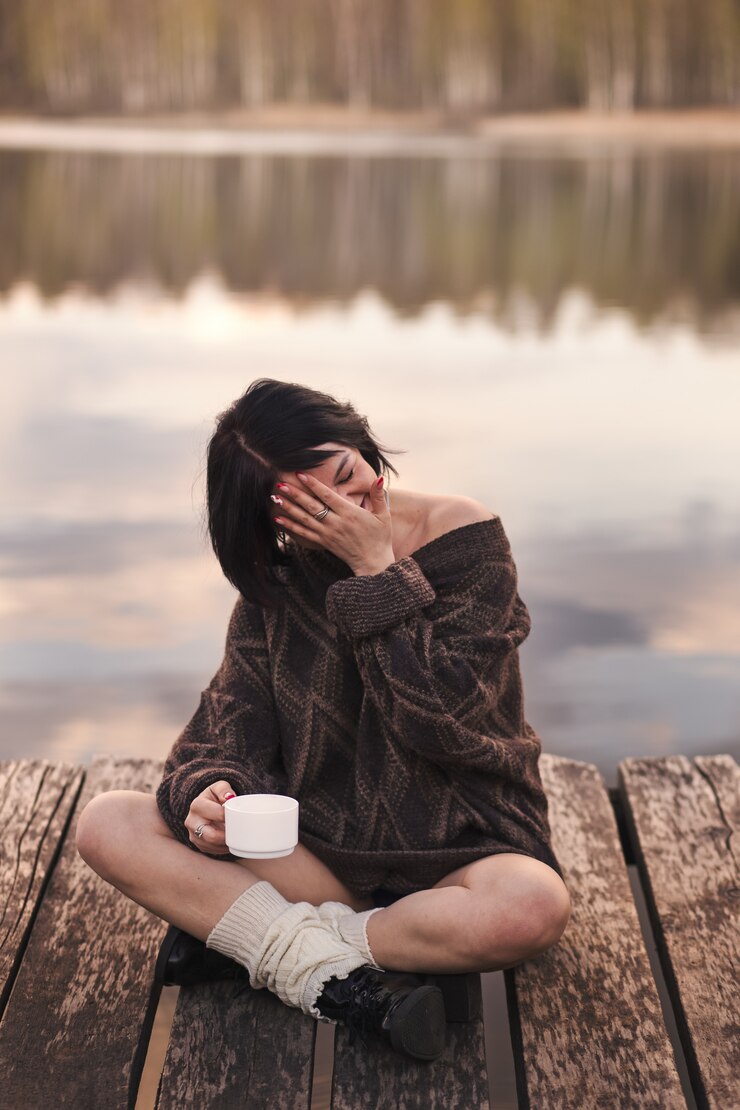 若い女の子は屋外の感情のコーヒーを飲む
