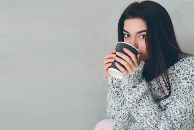 Young girl drinks delicious utensils of the coffe and thinks about plans for the day