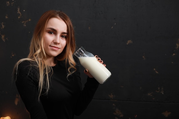 Photo young girl drinks milk from a bottle