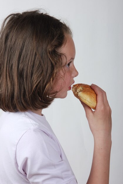 A  young girl eating a bun