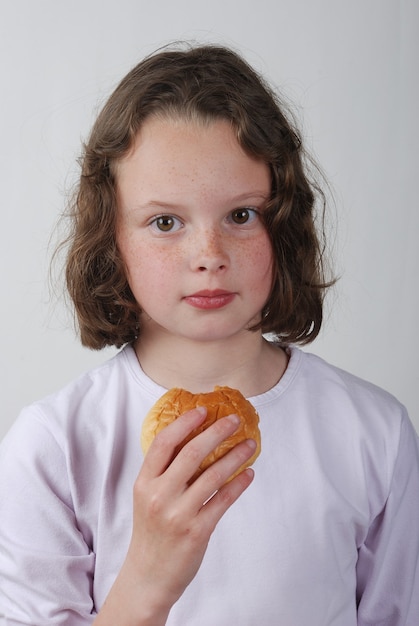 A  young girl eating a bun