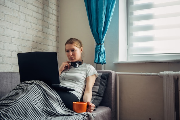 Young girl employee with laptop computer in self isolation working from home