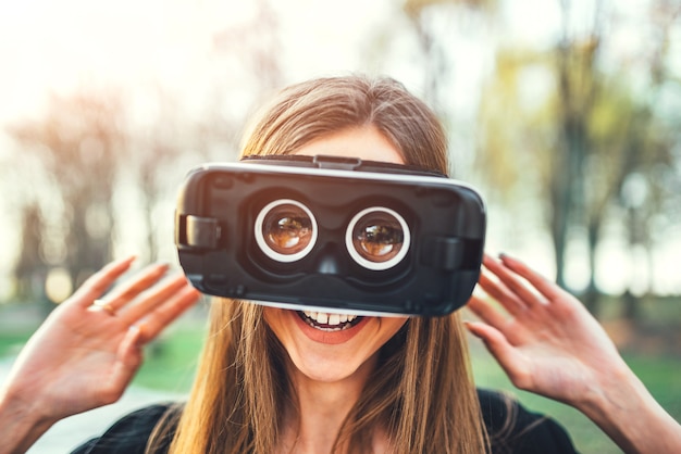 Young girl enjoy virtual reality glasses outdoor