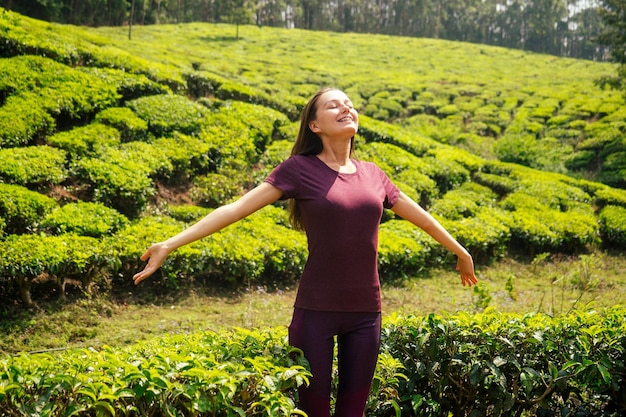 Молодая девушка наслаждается добрым утром на чайных плантациях в Индии Муннар Керала