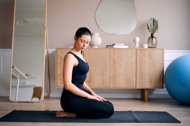 Young girl enjoying her yoga exercise at home.