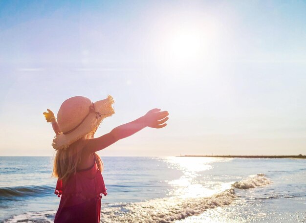 Young Girl Enjoying a Summer Day at the Beach at Sunset