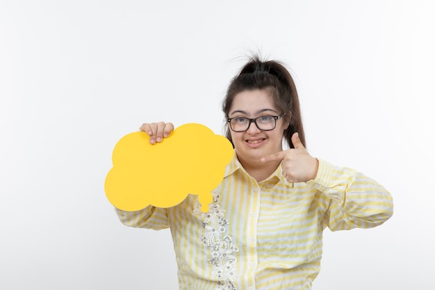 Photo young girl in eyeglasses holding yellow speech bubble.