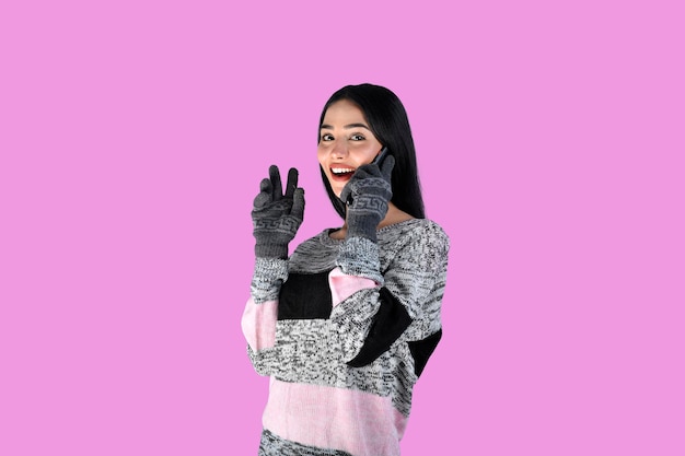 young girl front pose wearing winter clothes and gloves talking on phone indian pakistani model