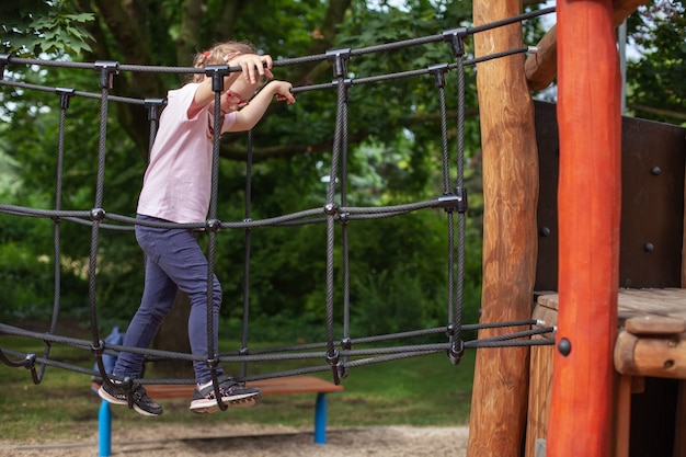 Young girl in glasses goes in for sports on the playground. rest and childhood outdoors