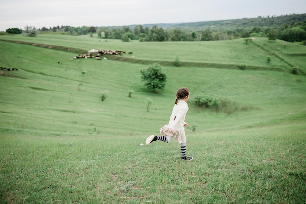 Young girl on the green hills on the farm