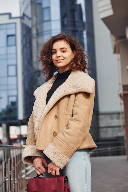 Young girl have a walk outdoors in the city near business building