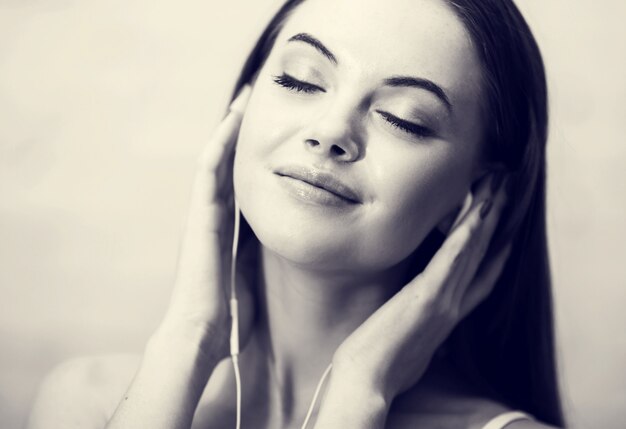 Young girl in headphones with mobile phone relaxing home. Monochrome.