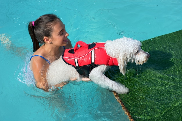 水から小さな犬を助ける若い女の子