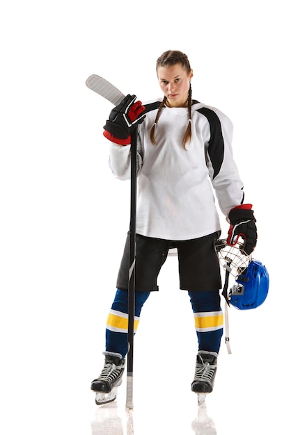 Foto giovane giocatrice di hockey in uniforme in piedi con un bastone e in posa isolata su sfondo bianco