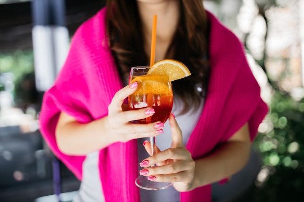 Молодая девушка держит коктейль aperol spritz Коктейль aperol spritz в стакане Девушка в ресторане со стаканом Aperol spritz в руках девушки Коктейль Aperol spritz