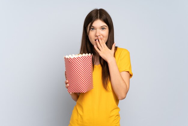 Young girl holding a big bucket of popcorns