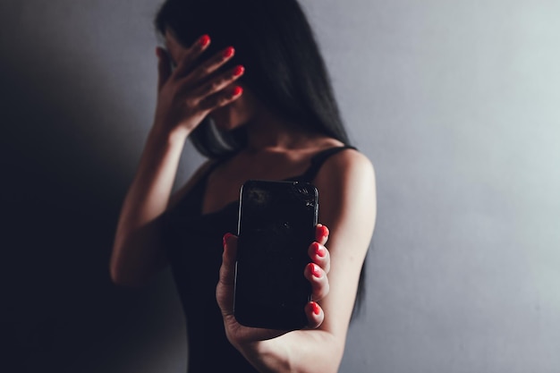 Young girl holding broken phone