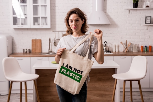 Young girl holding a cloth bag. At the kitchen. I am not plastic.