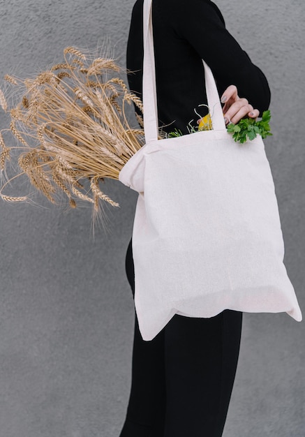 Young girl holding a cloth bag with ears of wheat