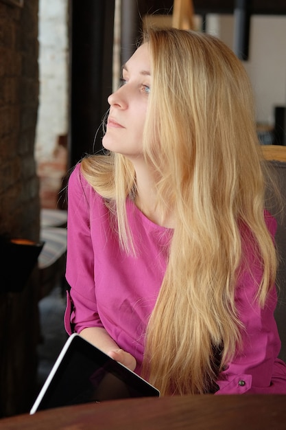 Foto ragazza che tiene una tavoletta digitale, computer. la donna di affari nel caffè fa affari. impiegato a pranzo. donne in una riunione nella hall dell'hotel.