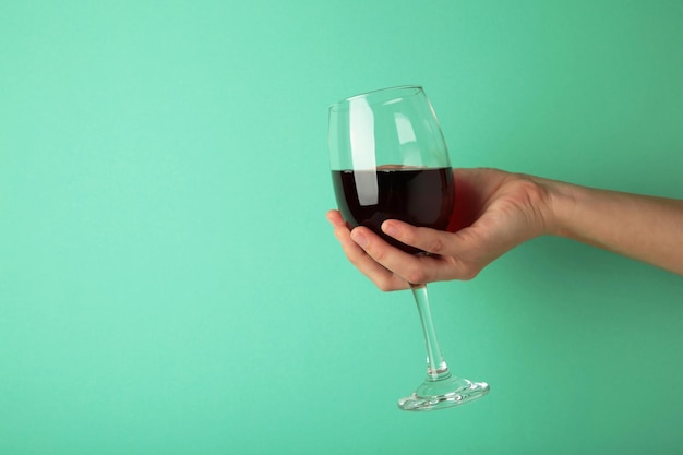 Young girl holding glass of tasty red wine on pink background Space for text Top view