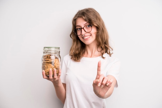 Young girl holding home made cookies bottle