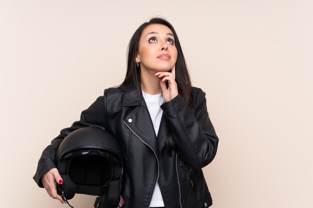 Young girl holding a motorcycle helmet over thinking an idea