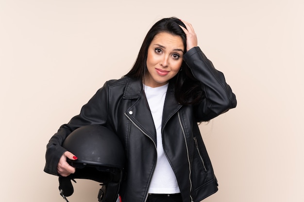 Молодая девушка, держащая мотоциклетный шлем с удивленным выражением лица