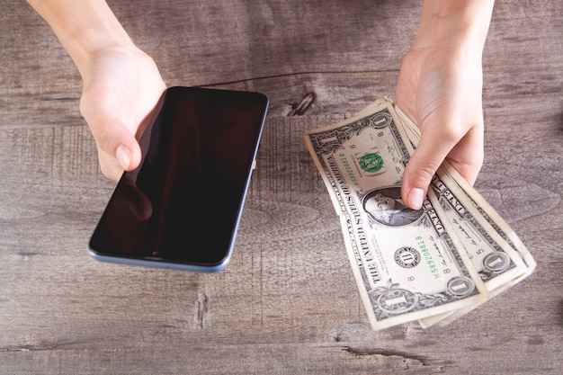 Young girl holding a phone and banknotes