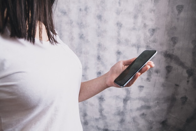 A young girl holding a phone in her hands