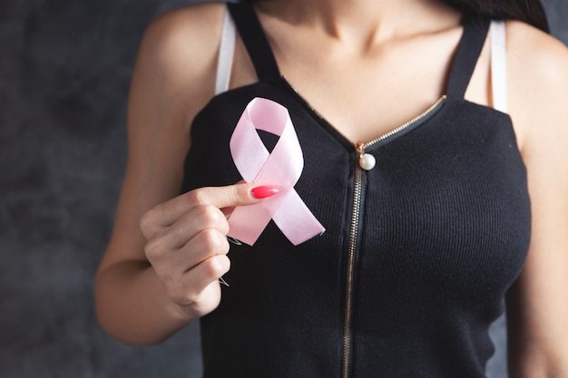 Young girl holding a pink ribbon