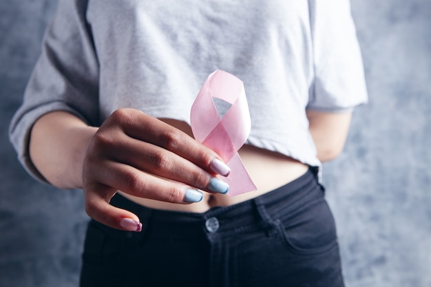 Young girl holding a pink ribbon