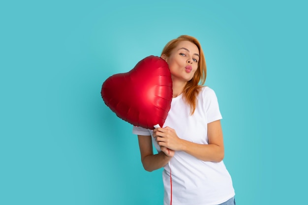 Young girl holding red air balloons Valentines day Isolated on blue background Woman air kiss