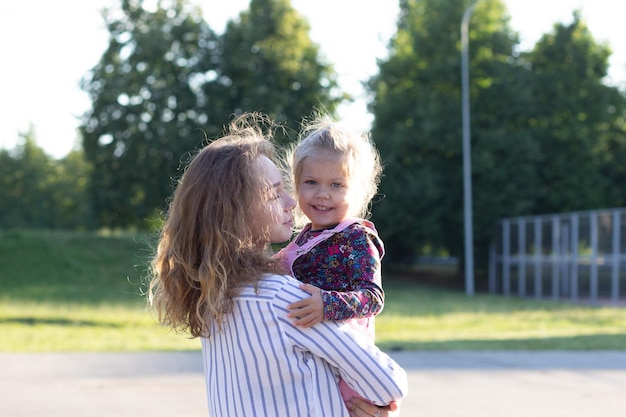 Young girl holding smiling and beautiful child looking at camera