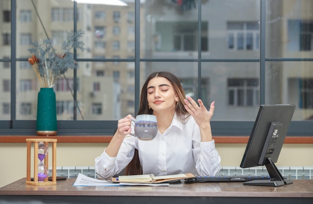 茶碗を持ってお茶の匂いを嗅ぐ少女