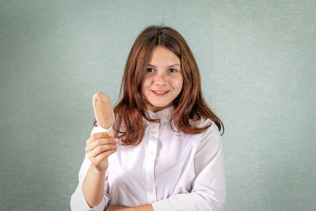 A young girl holds a chocolate ice cream.