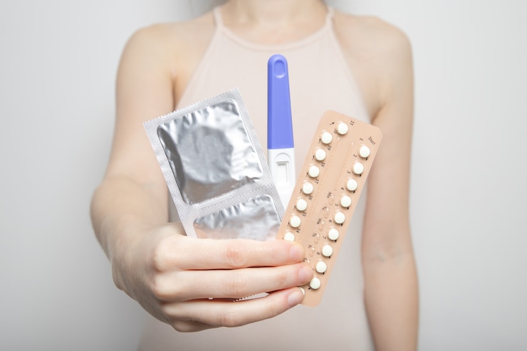 Photo a young girl holds contraception and a pregnancy test in her hands