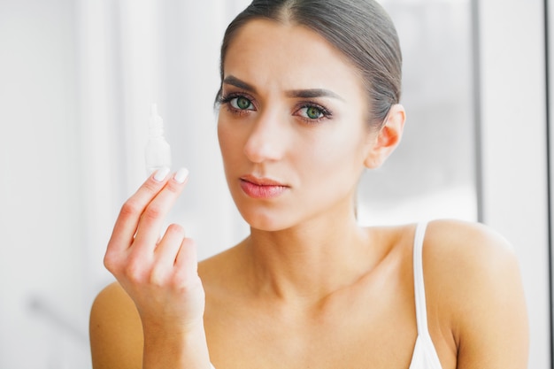 Young Girl Holds Eye Drops In Hands. 