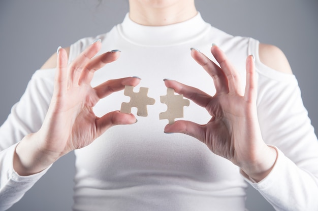 Young girl holds two pieces of puzzle