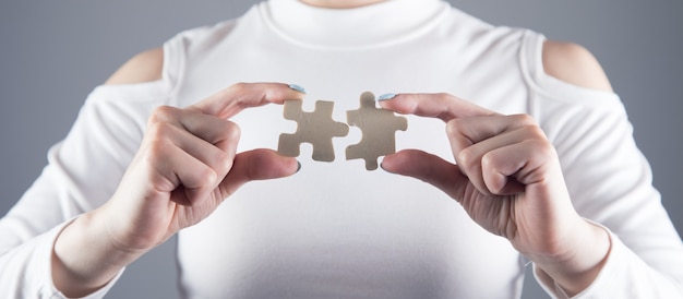 Young girl holds two pieces of puzzle