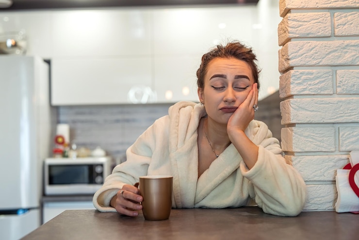 Photo young girl in home clothes got up early and drank sweet tea in the kitchen