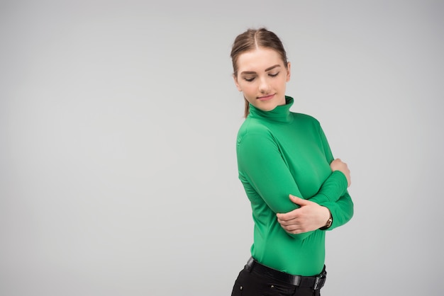 Photo young girl hugging herself posing in the studio and looking down