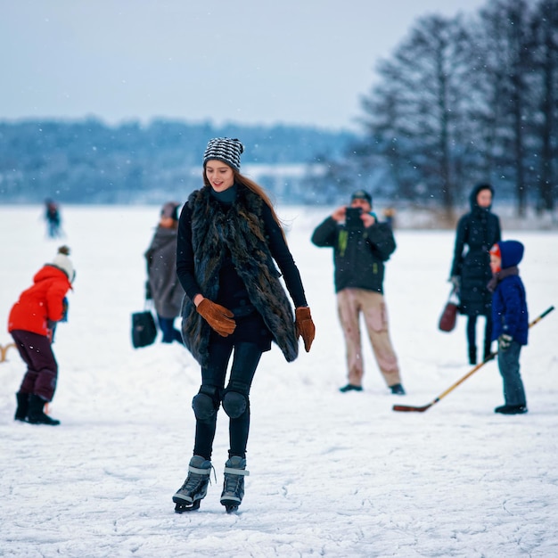 Young girl ice skating at winter rink covered with snow in Trakai in Lithuania.