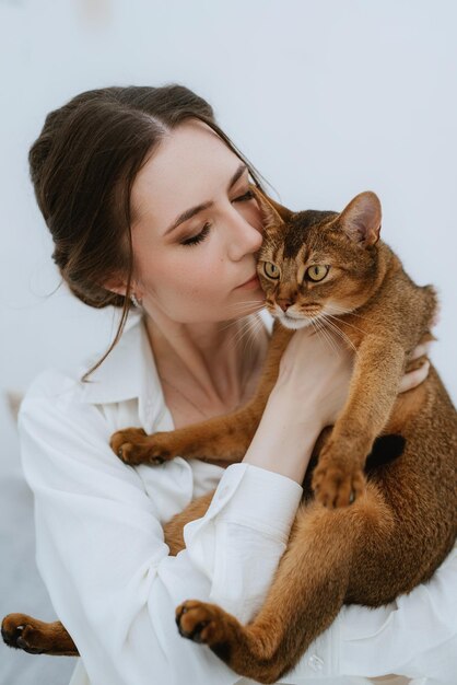 写真 白い部屋で猫と遊ぶ若い女の子