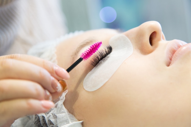 A young girl increases eyelashes in a beauty salon.