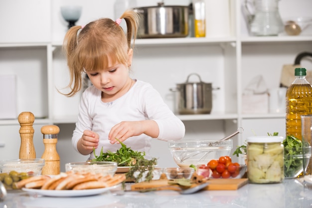 Young girl is cooking vegetables dish alone in the kitchen