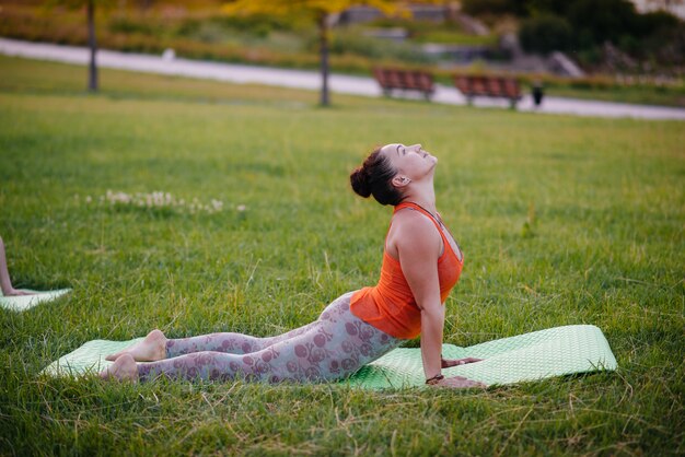 A young girl is doing yoga outdoors in a Park at sunset. Healthy lifestyle